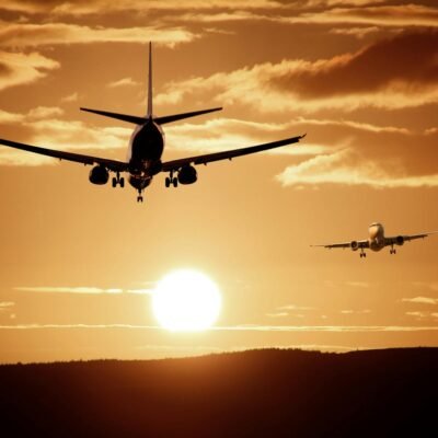 Silhouetted airplanes landing against a dramatic sunset sky, capturing the essence of flight.